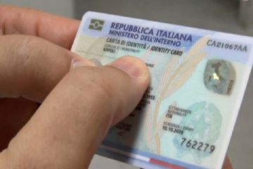 dita che tengono una carta identità elettronica